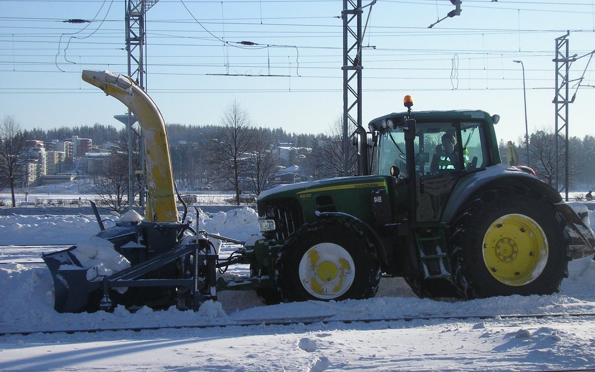 Entrée de garage résidentielle déneigée par tracteur avec souffleuse