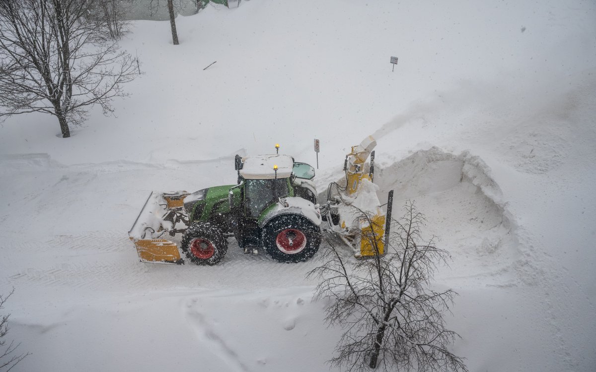 Tracteur de déneigement luttant contre le blizzard et la poudrerie