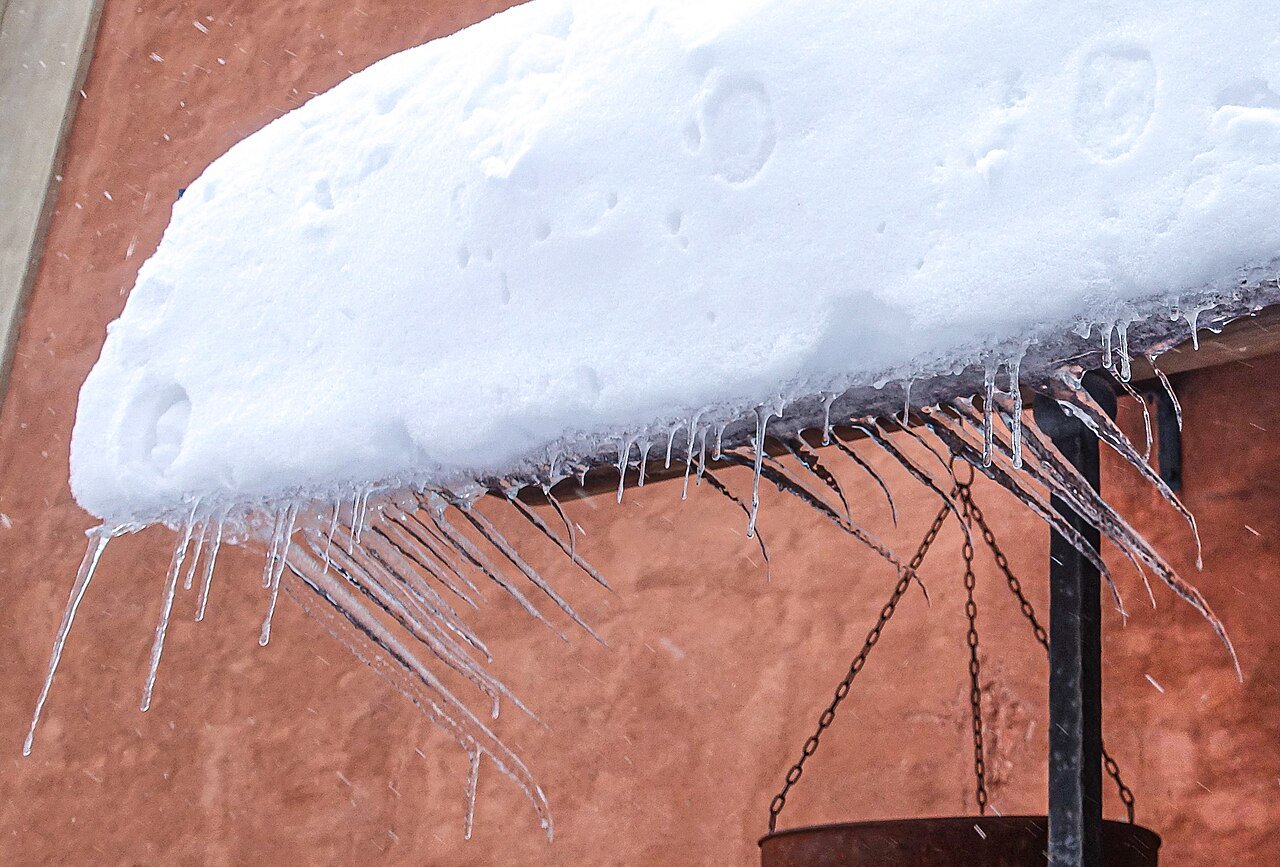Barrage de glace et glaçons massifs sur toit de maison