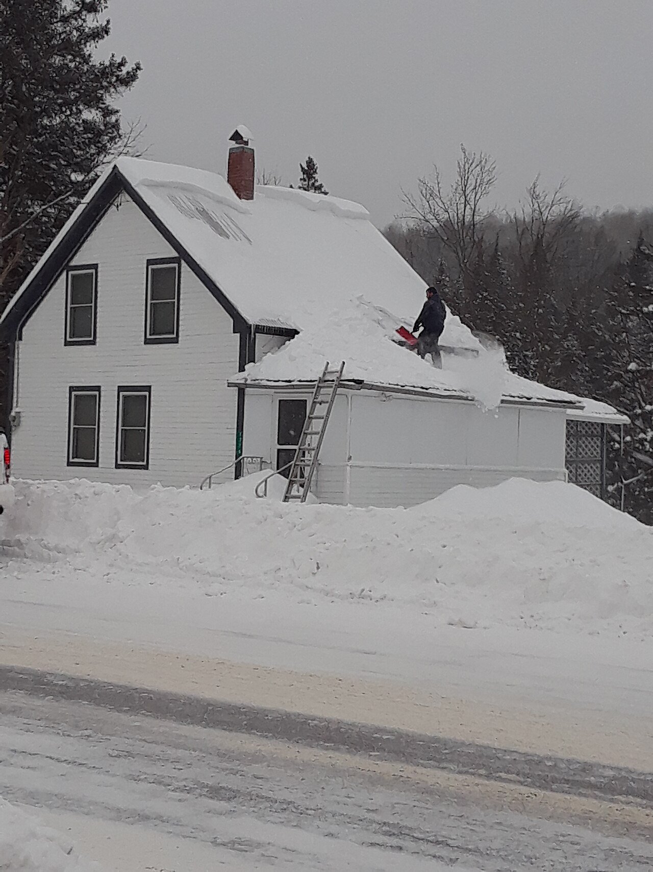 Équipe déneigeant une toiture résidentielle à Lévis
